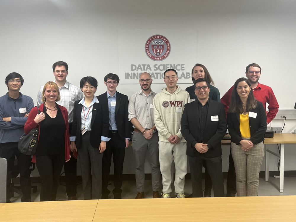WPI president Dr. Grace Wang stands with members of the DAISY group in the Data Science Innovation Lab .